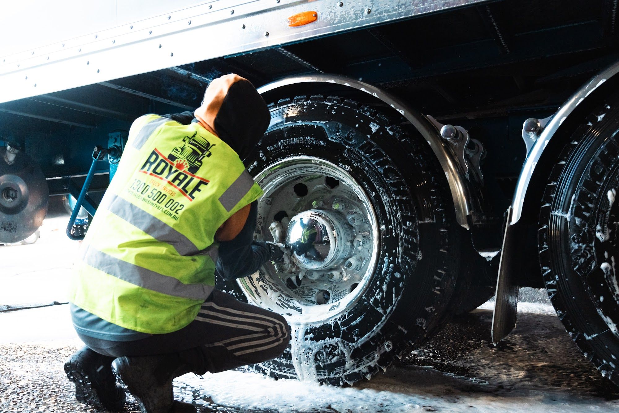 Royale team member washing a truck wheel